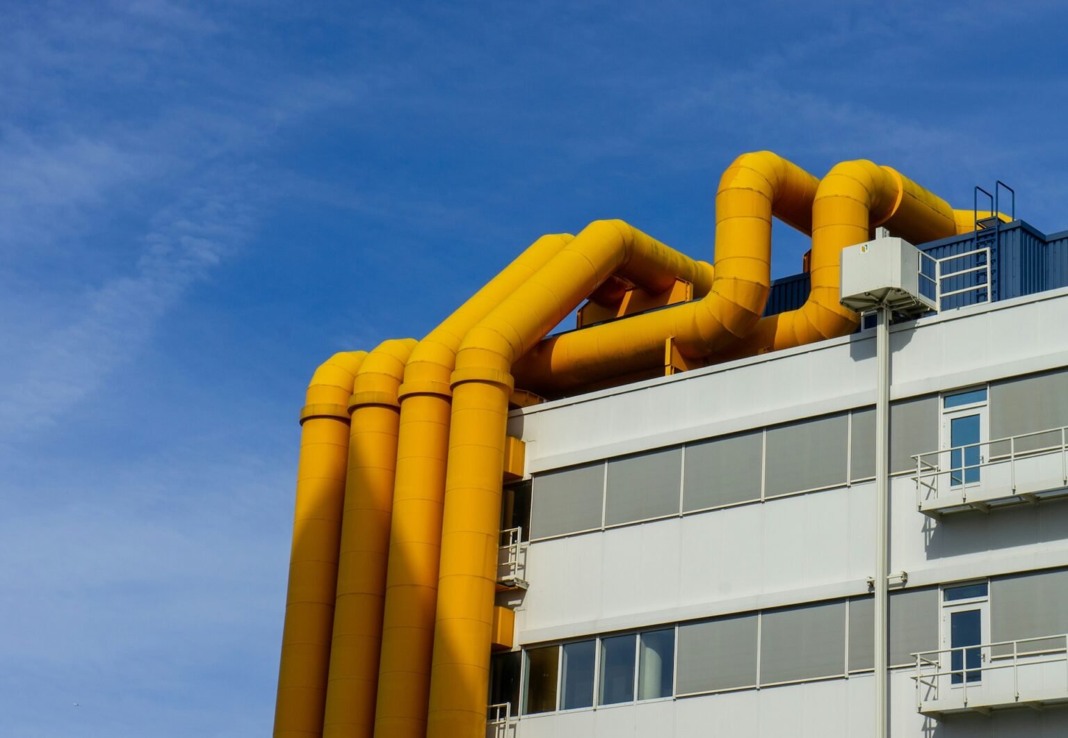 Sárga csővezetékek egy modern hőközpont tetején